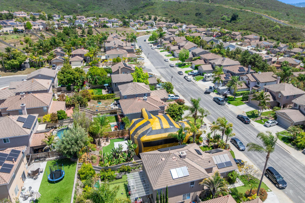 Aerial view of yellow and gray termite tent on a big house in san diego