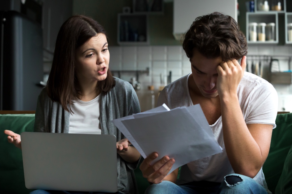 hoa-harassment-by-board-members Homeowner reviewing a stack of HOA violation notices, a common sign of HOA harassment by board members