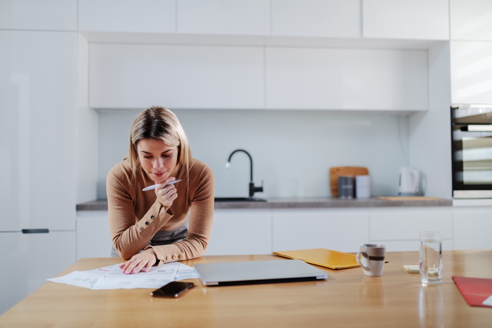 hoa-payment-plan Homeowner reviewing an HOA statement and a written payment plan at a kitchen table