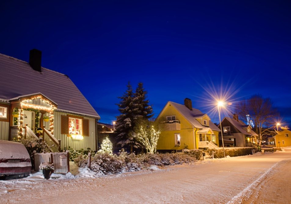 Townhomes decorated with holiday lights and wreaths in a planned community, illustrating HOA holiday decoration rules