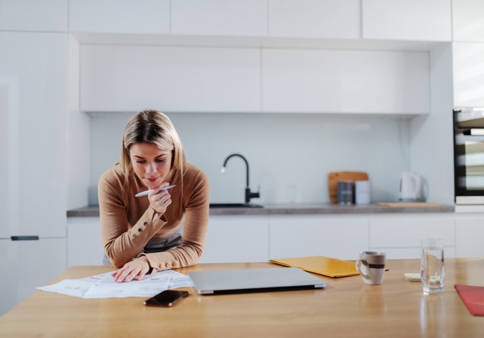 Homeowner reviewing an HOA statement and a written payment plan at a kitchen table